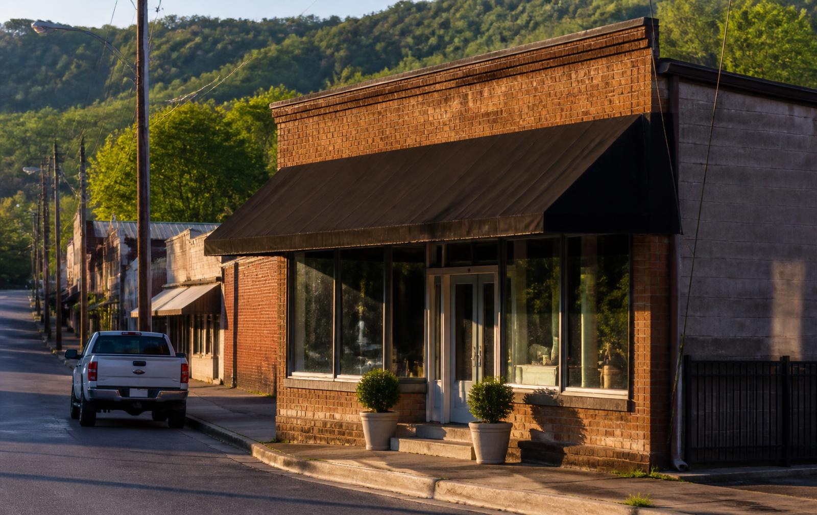Sawbriar Baking brick storefront on a quiet Monticello street with wooded hills behind